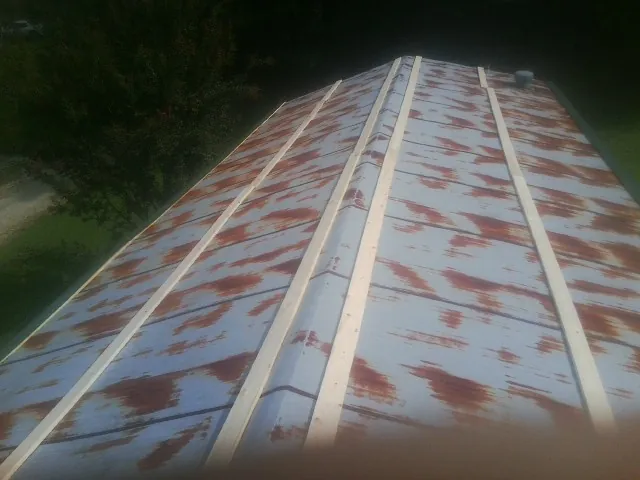 Rusted metal roof panels with new wood purlins before replacement — Storm Damage Roof Repair in Smallwood by Roofing Brothers