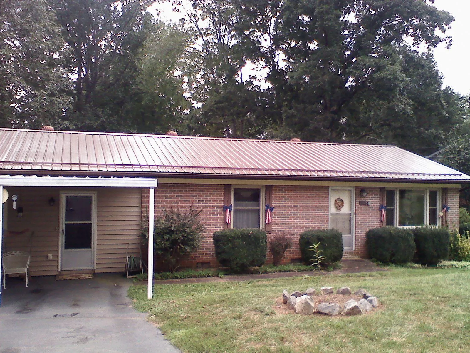 Bronze metal roof and carport on a brick ranch home — Roof Repair work by our crew in Smallwood