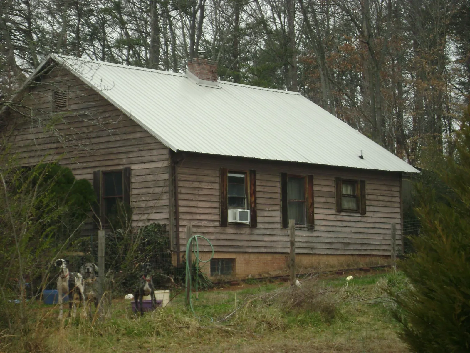 White metal roof on an old wood sided farmhouse, from a Metal Roof Installation job in Smallwood